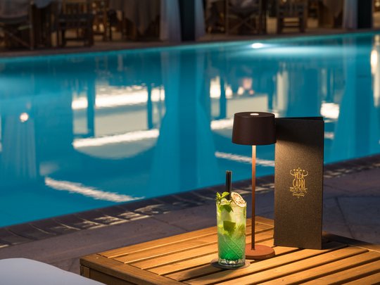 A laid-back holiday on Lake Garda at a 4-star hotel Cocktail and menu by pool with soft evening lamp light