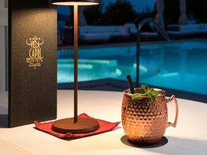 A laid-back holiday on Lake Garda at a 4-star hotel Copper mug with cocktail beside lamp and pool at night